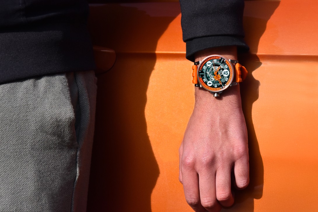 V6-44-SA mit skelettiertem Zifferblatt Orange, auf einer Rennkarosserie platziert